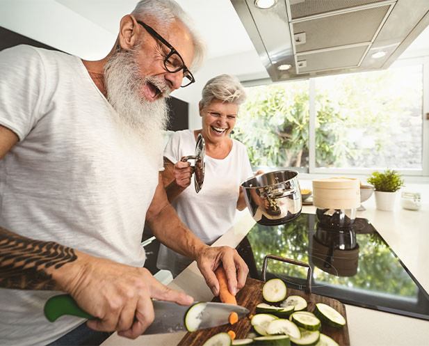 image of an older couple cooking and having fun at it