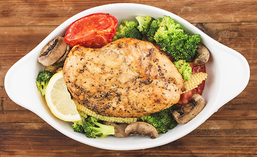 Baked chicken on a plate with veggies