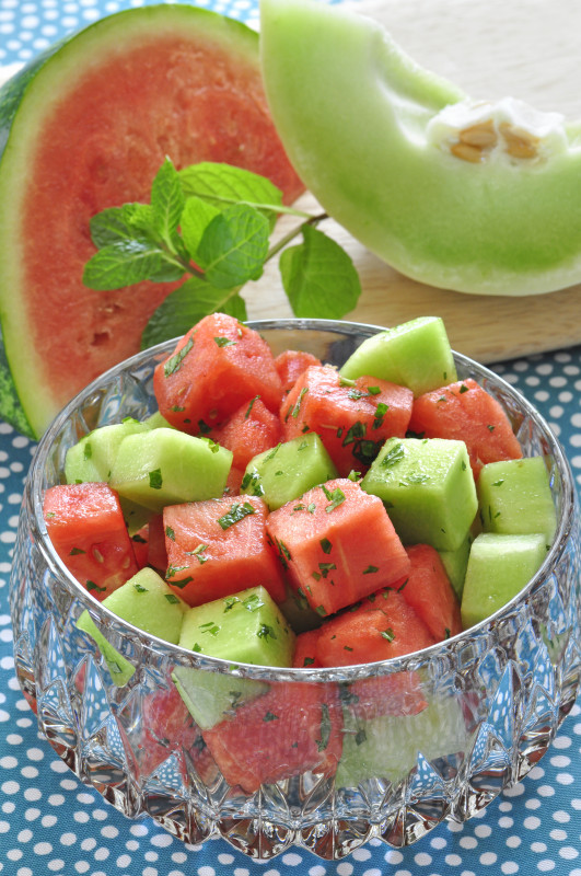 watermelon and honeydew melon in a bowl with chopped mint