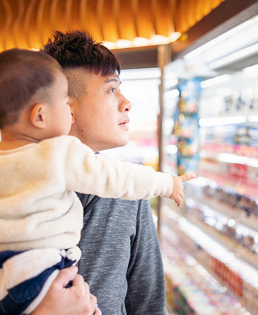 father and son in food store isle