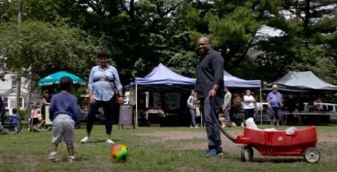 black family plays soccer together in park