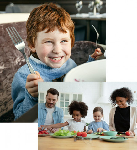 red head young boy holding fork knife multiracial family eating salad at table
