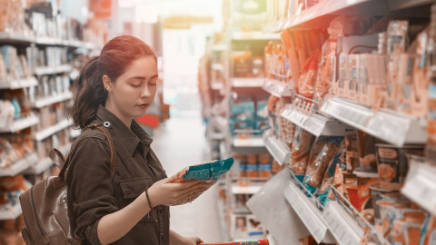 Woman in grocery store looking at package