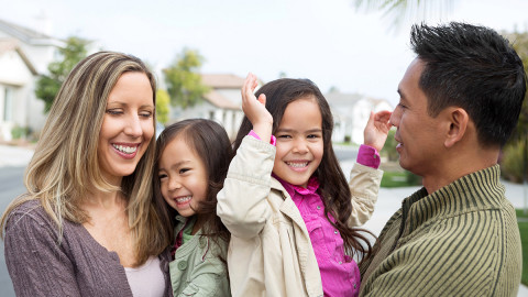 image of two parents holding their two daughters