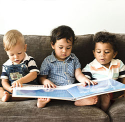 picture of young toddlers looking at a book