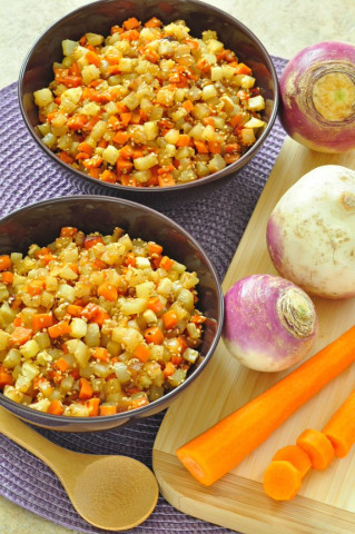 Bowl of sesame turnips and carrots with raw turnips on a cutting board