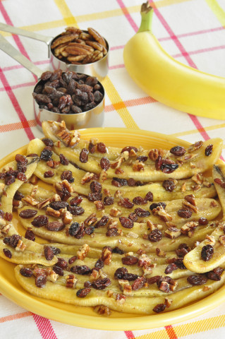 Baked bananas topped with raisins and chopped nuts