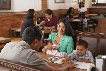 Breastfeeding woman with family and restaurant