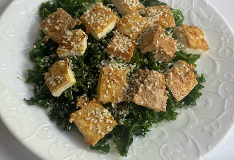Baked tofu on a bed of spinach