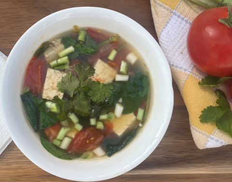 tofu, tomato, and spinach soup in a bowl