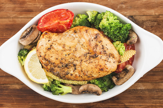 Baked chicken on a plate with veggies