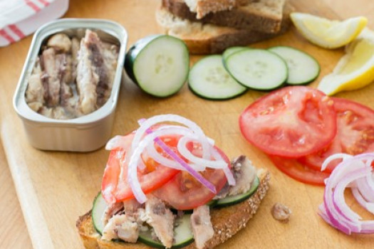 Sardine, Cucumber, and Tomato Sandwich on a cutting board