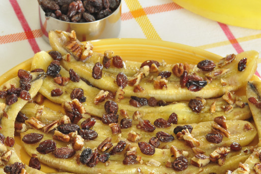 Baked bananas topped with raisins and chopped nuts