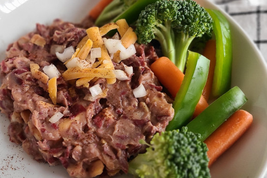 Bean dip on a plate with broccoli and carrots on the side