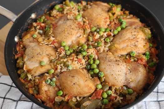 skinless chicken pieces with vegetables in a skillet