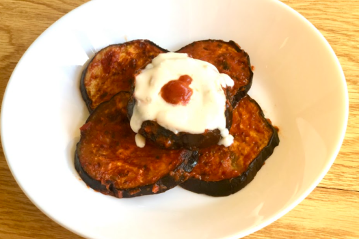 roasted eggplant topped with yogurt on a plate