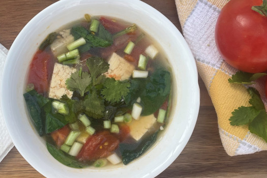 tofu, tomato, and spinach soup in a bowl