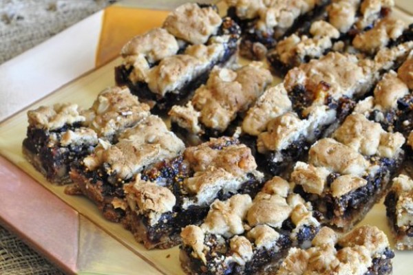 Fig bars on a cutting board with some figs next to the board
