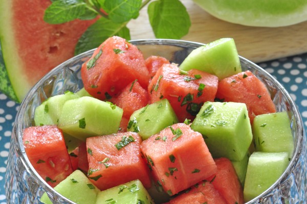 watermelon and honeydew melon in a bowl with chopped mint