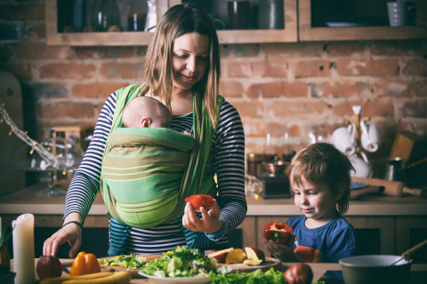 image of a pregnant woman looking at food with her child next to her
